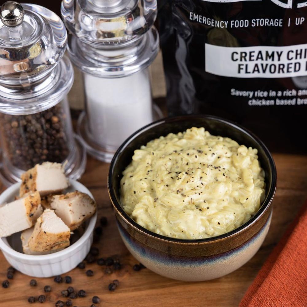 bowl of creamy chicken flavored rice and a pouch of the food sitting next to it