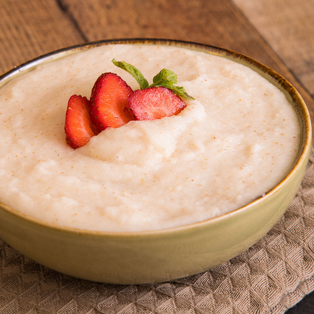 Bowl of smooth hot strawberry cereal with fresh sliced strawberry garnish