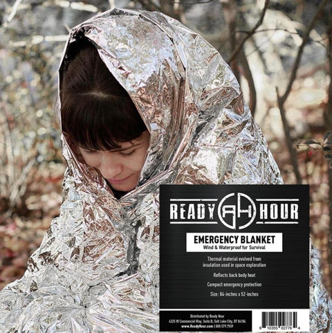 survivalist inside a ready hour emergency blanket in the woods