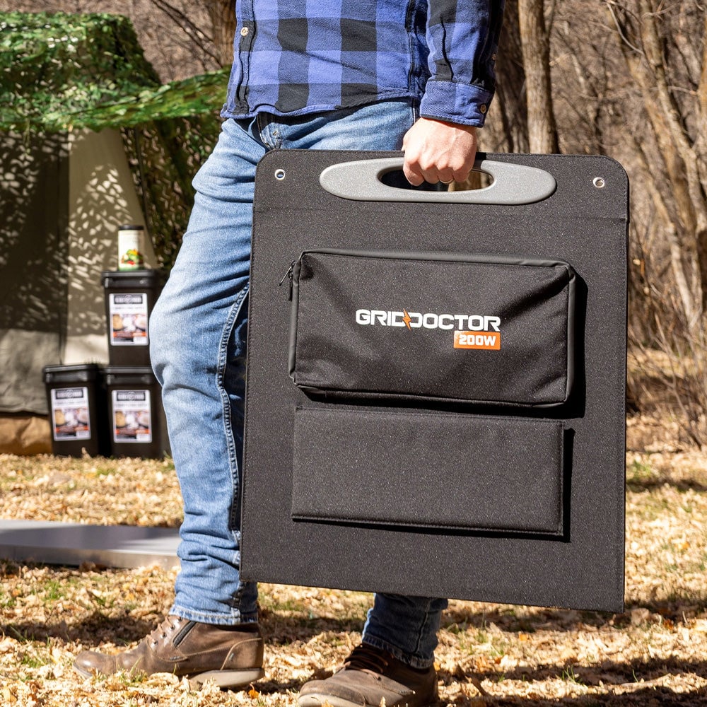 Shows a man carrying the folded Grid Doctor solar panel in its case.