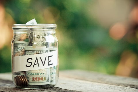 A jar of cash sitting on a table.