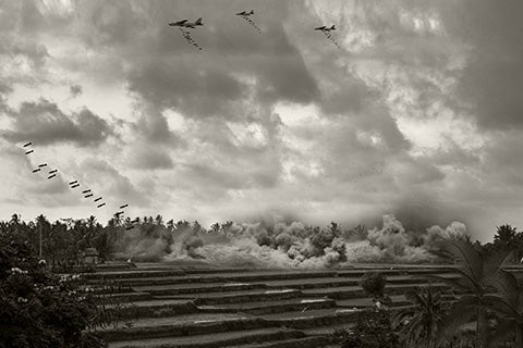 A black and white photo of planes bombing an area.